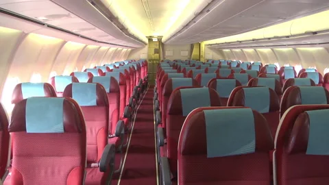 Empty seats of a passenger plane in a red-blue cabin Stock Footage 237348433