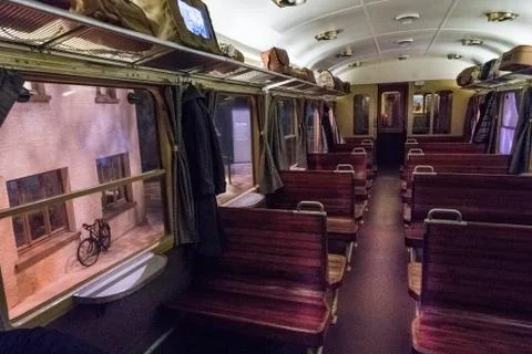 Empty seats in train carriage with view along aisle towards back of carriage. Stock Photos
