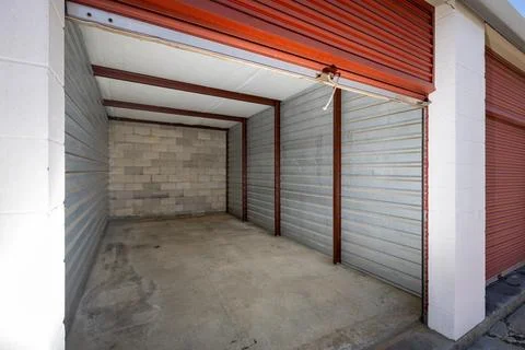 Empty self storage unit with roll up door Stock Photos