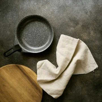 Empty serving pan, cutting board and linen napkin, top view, close up Stock Photos