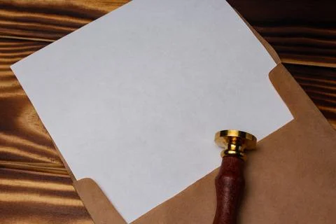 Empty sheet of paper in the envelope and stamp on wooden background Stock Photos