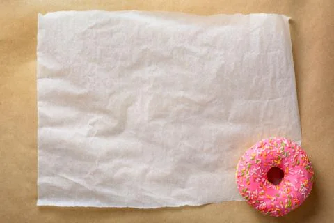 An empty sheet of paper for your text and an appetizing pink donut Stock Photos