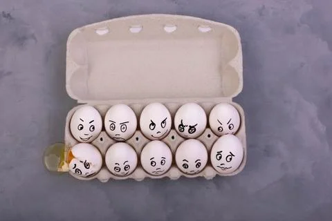 An empty shell, broken egg with different faces. Eggs in box Stock Photos