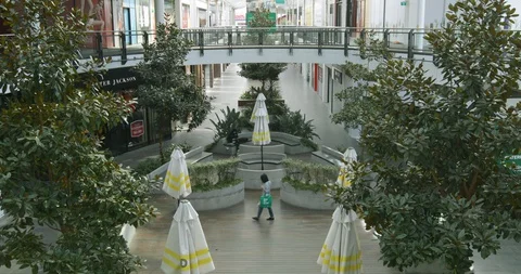 Empty Shopping Mall With Lone Shopper During Coronavirus Shutdown Stock Footage 129349836