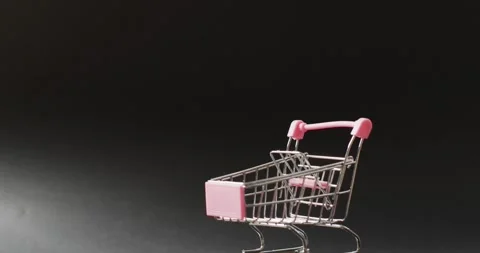 Empty shopping trolley on seamless, lit black background with copy space Stock Footage 337623496