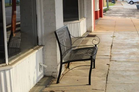 Empty sidewalk bench. Stock Photos