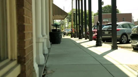 Empty sidewalk in front of small town stores Stock Footage 236707992