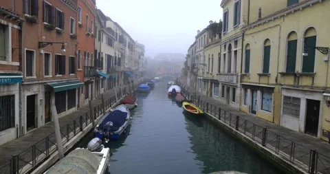 Empty sidewalk next to a canal closed doors moored boats abandoned town concept Stock Footage 150155659