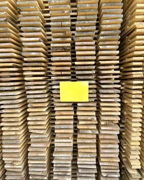 Empty sign on a stack of wooden building materials. a warehouse with products, a Stock Photos