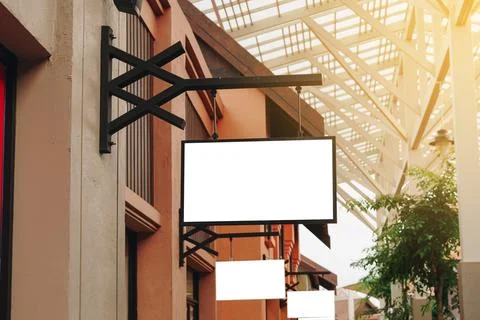 Empty signage and blank mock up hanging on street with copy space Stock Photos