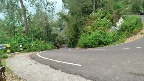 An empty silent highway in the middle of a forest mountain Vídeos de archivo 341827355