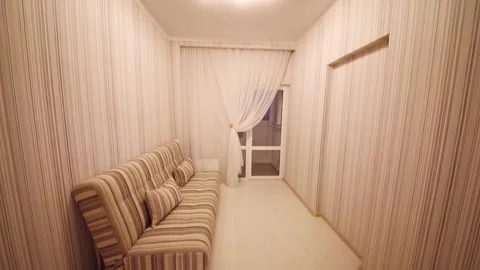 Empty simple cozy room striped walls and striped sofa at night Stock Footage 276359259
