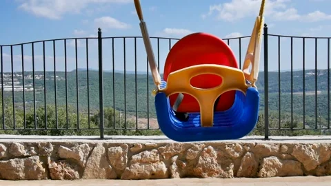 Empty single swing left alone. No people. No children. Seat of a colorful Stock Footage 133269341