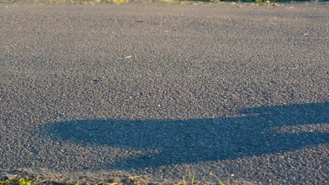 An empty skateboard rides on an asphalt track Stock Footage 131806563