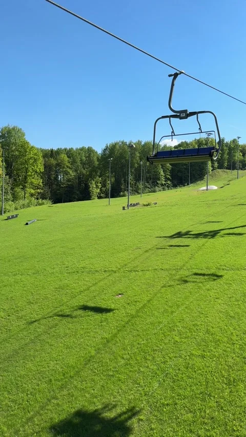 Empty ski lift above green summer mountain slope Stock Footage 336192033