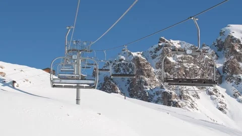Empty ski lift chairs glide over snowy Tetnuldi slope, capturing pristine w.. Stockbeeldmateriaal 311649747