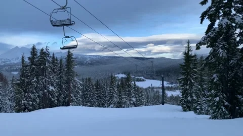 Empty ski lift chairs going up and down the mountain with beautiful scenic 動画素材 220240142