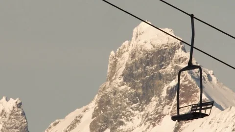 Empty ski lift moving against the snow covered mountain Stock Footage 77765205