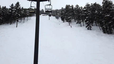 Empty ski lift view going up a steep snow covered mountain, hiker can be Stock Footage 112342703