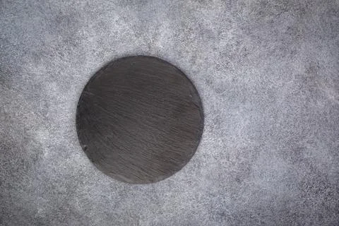 Empty slate round platter on gray Stockfoto's