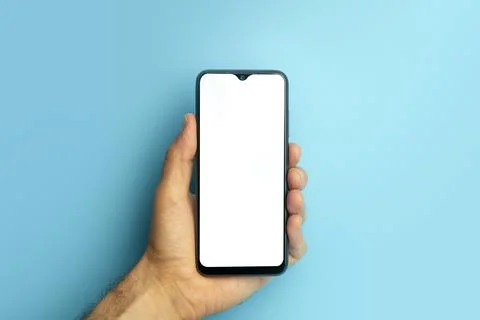 Empty smartphone in hand on colored blue banner background. Mockup phone with Stock Photos