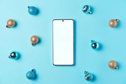 Empty smartphone screen with balls on blue background from above. Christmas.. Stock Photos