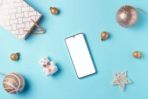 Empty smartphone screen with decorations on blue background from above. Chr.. Stock Photos