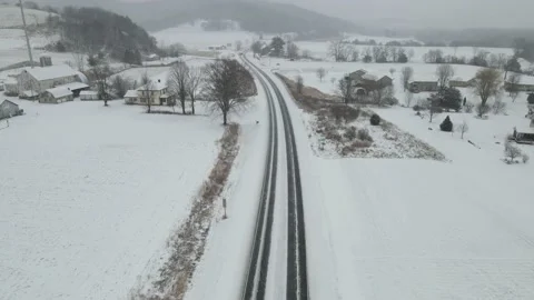 Empty snow covered highway through farm fields in valley. Video stock 166266488