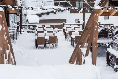 Empty snow covered outdoors cafe in the mountains. Empty snow-covered tables of Stock Photos