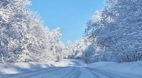 Empty snow-covered road in winter landscape. snowy road in the forest . Stock Photos