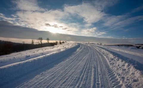 Empty snow covered road in winter landscape Stock Photos