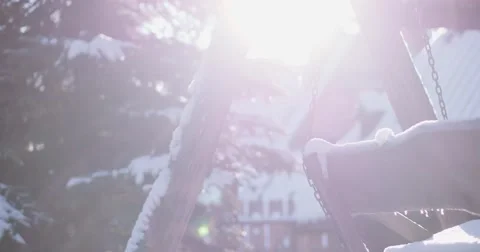 Empty Snow-Covered Swing in Sunny Winter Garden. 4K DCi SLOW MOTION 120 fps. Vídeo Stock 67217948