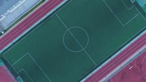 Empty soccer field and running track aerial top-down view rotating slowly Vidéo 348198487