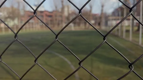 An Empty Soccer Field Behind a Chain Link Fence on a Clear Sunny Day in the City Stock Footage 305268511