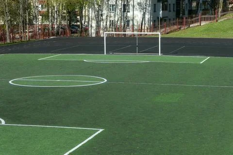 Empty soccer field with green artificial turf and white goals at school sta.. Stock Photos