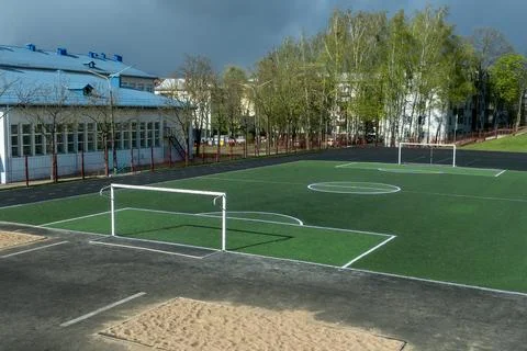 Empty soccer field with green artificial turf and white goals at school sta.. Stock Photos