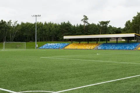 Empty soccer field with stadium seating. Green grass pitch at a local sport.. Фото