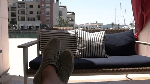 An empty sofa and waving in the wind curtains in a summer cafe in the outdoors Stock Footage 96588439