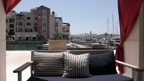 An empty sofa and waving in the wind curtains in a summer cafe in the outdoors Stock Footage 96590680