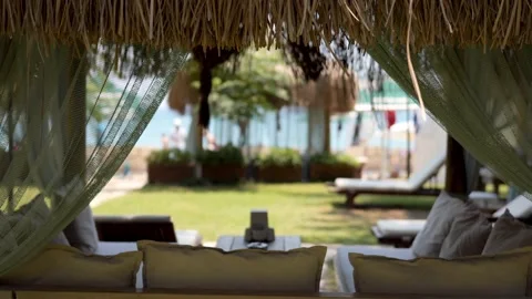 An empty sofa and waving in the wind curtains in summer cafe outdoors Stock Footage 232106349