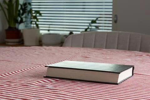Empty space background. A book rests on a red and white striped bedspread i.. Stock Photos