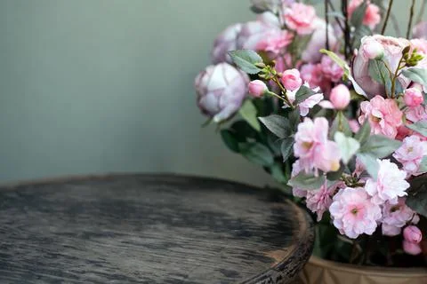 Empty space on a wooden table next to a bouquet of artificial flowers. Spring Stock Photos