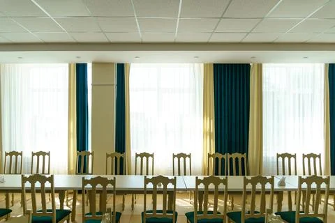 An empty spacious banquet hall with tables and chairs and panoramic windows.  Stock Photos