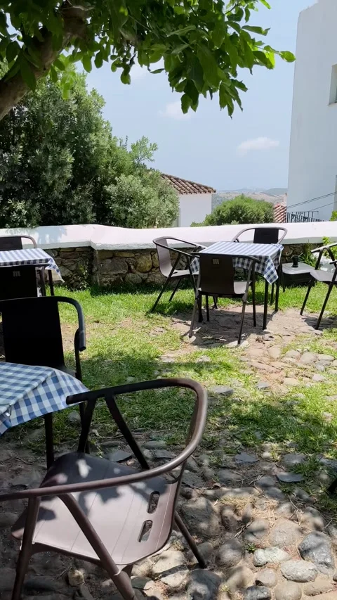 Empty Spanish outdoor terrace with checkered tablecloths on a windy day Stock Footage 344412282