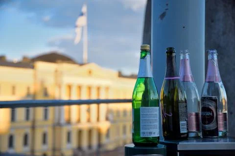 Empty sparkling wine bottles and Finnish Government Palace on May Day evening Stock Photos