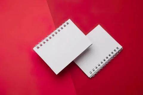 Empty spiral notepads on red and white background 스톡 사진