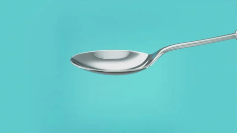 Empty spoon turning to spill out the contents. Cut out on blue screen Vidéo 267228948
