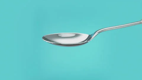 Empty spoon turning to spill out the contents. Cut out on blue screen Vidéo 267232021