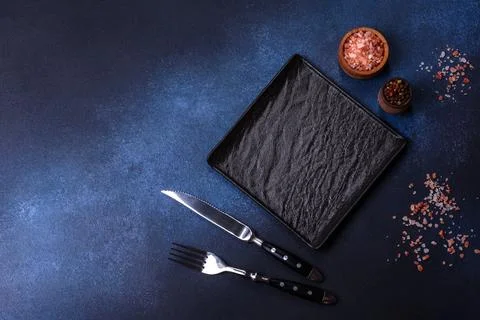 Empty square black plate on dark moody background with copy space Stock Photos