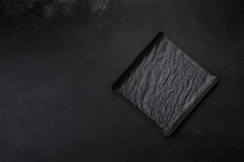 Empty square black plate on dark moody background with copy space Stock Photos